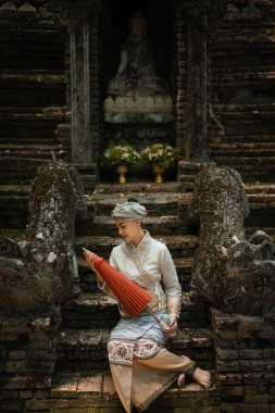 Geleneksel kostümlü güzel Asyalı kadınlar Wat Palad ya da Wat Pha Lat tapınaklarını ziyaret eder ve Chiang Mai, Tayland 'daki Budist inanışlarına göre antik tapınaklara dua ederler. Din kavramı.