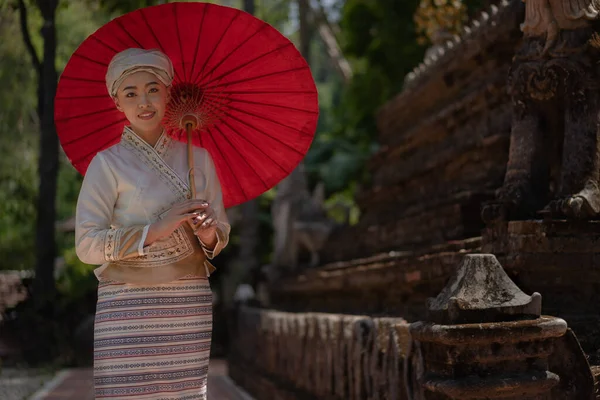 Geleneksel kostümlü güzel Asyalı kadınlar Wat Palad ya da Wat Pha Lat tapınaklarını ziyaret eder ve Chiang Mai, Tayland 'daki Budist inanışlarına göre antik tapınaklara dua ederler. Din kavramı.