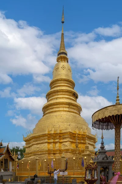 Lamphun, Tayland - 22 Mart 2022: Wat Phra 'daki antik güzel Altın Pagoda Hariphunchai tapınağı Lamphun, Kuzey Tayland' da mavi gökyüzü ile turistler arasında en popüler yer..