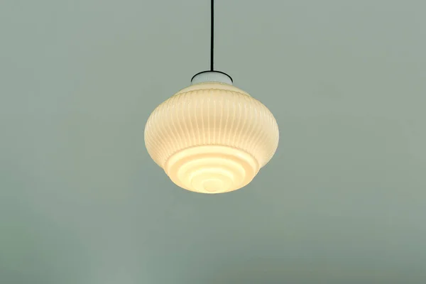 Beautiful modern ceiling lamp lights bulbs pleated round milky white glass bulbs vintage style and pastel green ceiling decoration for home and living.  Building interior concept.