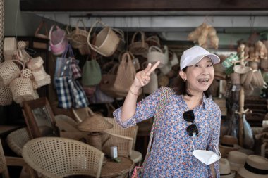 Eski bir dükkândan alışveriş yapan Asyalı turist kadın, şehir merkezindeki ünlü yerlerde Chang Moi Yolu, Chiang Mai, Kuzey Tayland 'da kültür ürünleri üretiyor..
