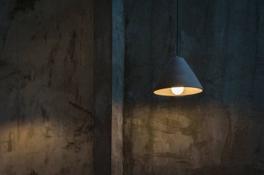 Güzel modern tavan lambası ampulleri beton duvarda üçgen şekilli şekilli dekorasyonlar klasik ruh hali tonlama renginde metin için yer var. Ofis inşa konsepti için çağdaş iç mimari.