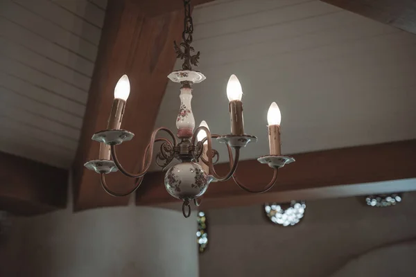 Antique ceramic red rose pattern chandelier lamp lighting bulbs on the ceiling with copy space interior for home and living retro-style building. Concept vintage lighting classic house decoration.