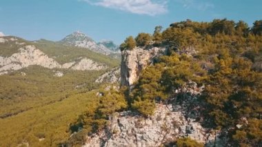 Taurus Dağları 'nın hava görüntüsü. Dağlar, tepeler, uçurumlar, kayalar, çıkıntılar, manzara, yeşil çimenler, gökyüzü, bulutlar, doğa, işlenmemiş doğa, çam ormanları, drone videosu.