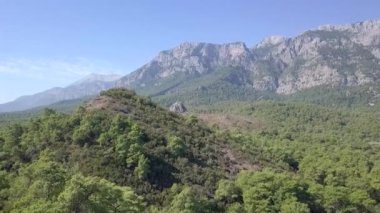 Taurus Dağları 'nın hava görüntüsü. Dağlar, tepeler, uçurumlar, kayalar, çıkıntılar, manzara, yeşil çimenler, gökyüzü, bulutlar, doğa, işlenmemiş doğa, çam ormanları, drone videosu.