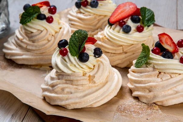 Orman meyveleri ve çileklerle süslenmiş kremalı tatlı. Kremalı pasta, yumurta beyazı ve pudra şekerinden yapılan köpüklü bir kurabiye türüdür. Fransızca 