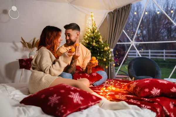 Neşeli Genç Çift Noel Akşamı Yatakta Otururken Mandalinalarla Oynuyorlar — Stok fotoğraf