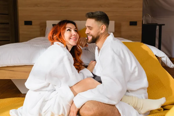 Joven Pareja Cariñosa Abrazándose Sentado Cara Cara Suelo Cerca Cama — Foto de Stock