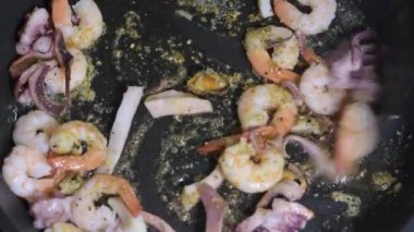 Baharatlı bir tavada deniz ürünleri kızartıyorum. Yakın plan..