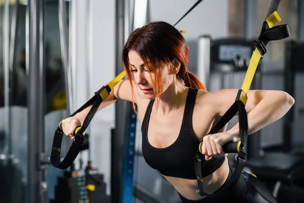 Making perfect body. Young athletic woman exercising with suspension straps  in the gym. Professional sport. TRX Training. Workout Stock Photo - Alamy