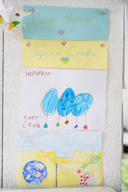 Dnipro, Ukrayna - 4 Nisan 2022: Ukrayna 'daki savaş hakkında birçok çocuk çizimi. Ukrayna 'da barış ile ilgili çocuk mesajlarıyla dolu bir duvar. Dnipro 'daki Mülteci Yardım Merkezi.