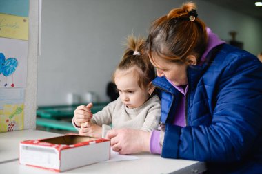 Dnipro, Ukrayna - Nisan 04, 2022: Torunuyla birlikte Dnipro 'daki bir mülteci merkezinde.