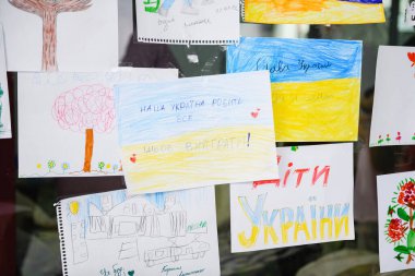 Dnipro, Ukrayna - 4 Nisan 2022: Ukrayna 'daki savaş hakkında birçok çocuk çizimi. Ukrayna 'da barış ile ilgili çocuk mesajlarıyla dolu bir duvar. Dnipro 'daki Mülteci Yardım Merkezi.