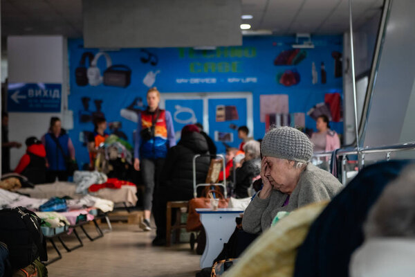 Dnipro, Ukraine - April 04, 2022: Sad elderly woman sitting on a cot at the Refugee Relief Center in Dnipro.