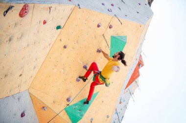 Genç ve formda bir adam dışarıda dağ tırmanışı yapıyor. Üst görünüm.