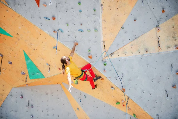 Genç ve formda bir adam dışarıda dağ tırmanışı yapıyor. Üst görünüm.