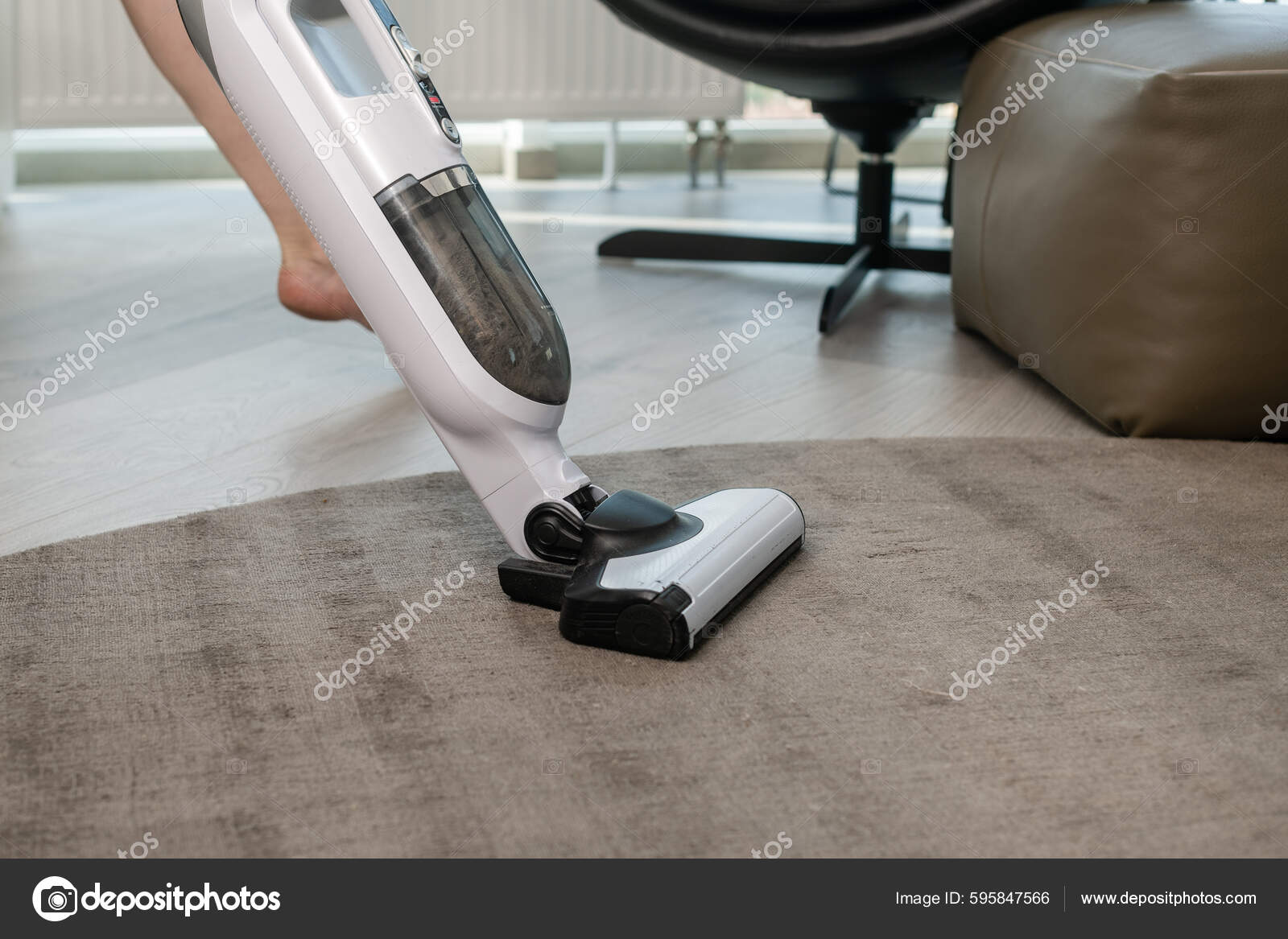 El ama de llaves está extrayendo la suciedad del sofá tapizado usando una  máquina extractora de