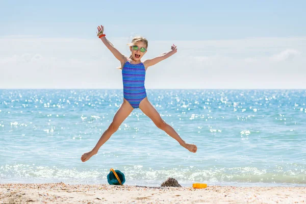 Klein Gelukkig Meisje Badpak Zonnebril Springen Als Ster Zee Strand — Stockfoto