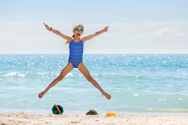 Klein Gelukkig Meisje Badpak Zonnebril Springen Als Ster Zee Strand — Stockfoto