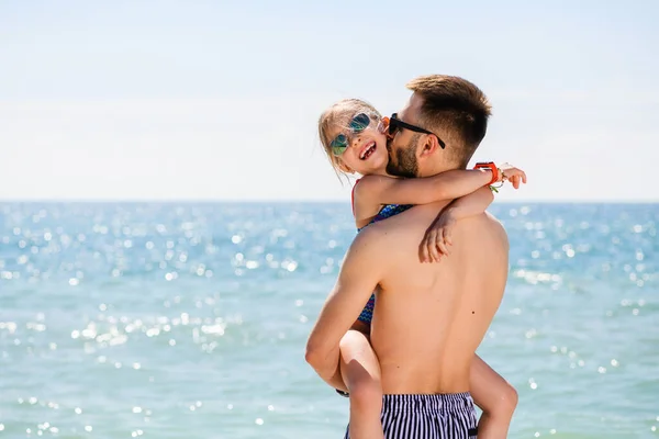 Ευτυχισμένο Κορίτσι Γυαλιά Ηλίου Αγκαλιά Νεαρός Πατέρας Στη Θάλασσα Παραλία — Φωτογραφία Αρχείου