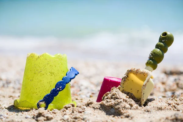 彩色塑料砂桶和铲子玩具在海滩宏观关闭 家庭度假与孩子的概念 — 图库照片