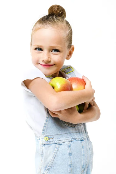 Roztomilé Dívka Oblečená Džínové Kombinézy Drží Náruč Plnou Čerstvých Jablek — Stock fotografie