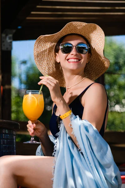 假日快乐的女孩 穿着泳衣 戴着眼镜 头戴太阳镜 喝柑橘类鸡尾酒 有着夏日的积极向上的精神 — 图库照片