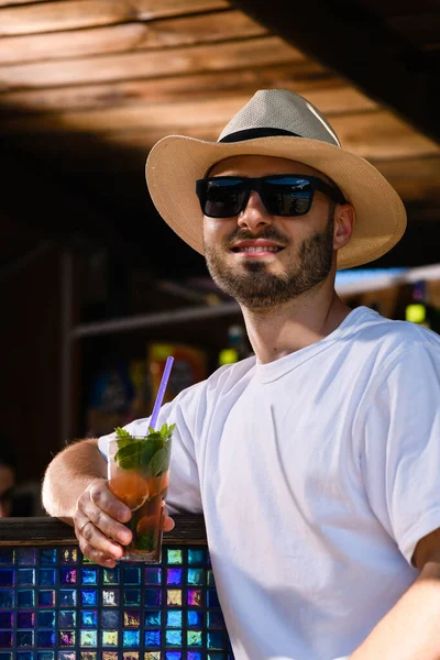 Νεαρός Χαμογελαστός Άνδρας Γυαλιά Ηλίου Και Ψάθινο Καπέλο Πίνοντας Κοκτέιλ — Φωτογραφία Αρχείου
