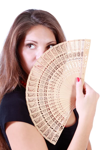 Beautiful girl looks away and hides her mouth and nose by fan is — Stock Photo, Image