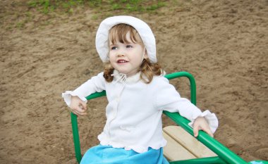 pla, küçük atlıkarınca üstünde beyaz panama giyen llittle kız rides