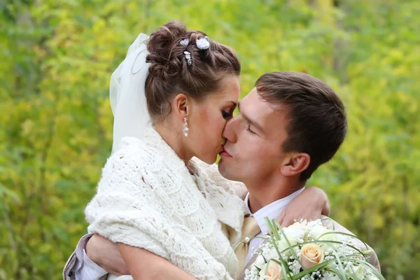 Feliz joven novia y novio abrazo y beso en el bosque de otoño — Foto de Stock