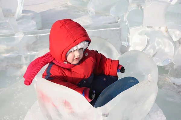 Ragazzina che indossa tuta calda si siede in ghiaccio nenuphar in inverno — Foto Stock