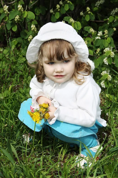 Beautiful little girl wearing white panama with yellow dandelion — Stock Photo, Image