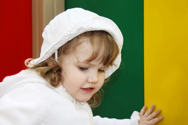 Beautiful little girl wearing white panama plays at playground — Stock Photo, Image