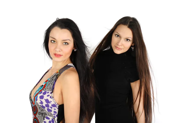 Two beautiful brunette girls look at camera inside white studio — Stock Photo, Image