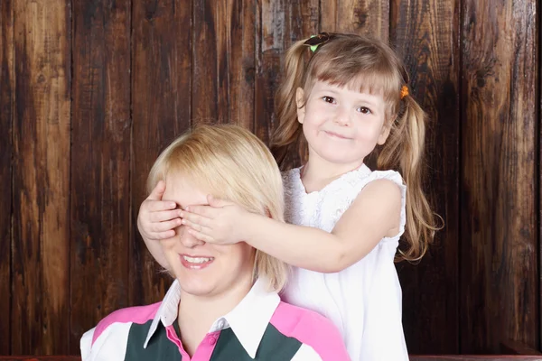 Beautiful little girl in white dress closes eyes to her mother. — Stock Photo, Image