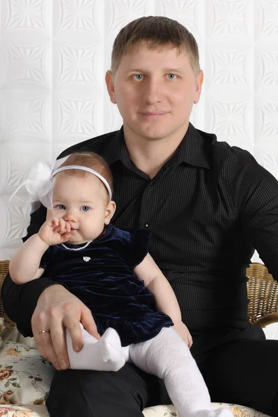 Glücklicher junger Vater und seine kleine süße Tochter sitzen auf Weiden, so — Stockfoto