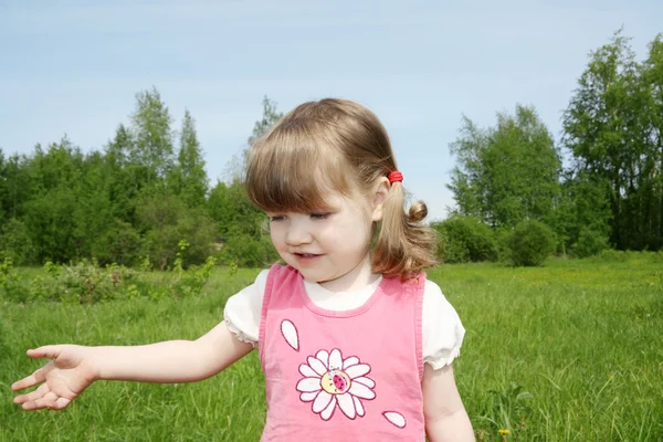 Little cute girl smiles at small field at sunny summer day outdo — Stock Photo, Image