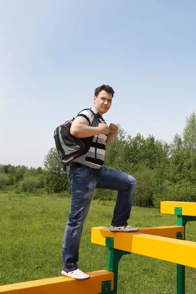 Yaz günü açık havada oyun alanı, sırt çantası ile genç adam. — Stok fotoğraf