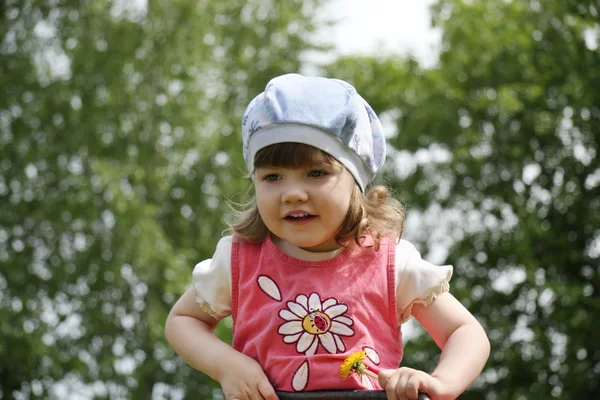 Glad liten söt flicka i rosa klänning på sommaren dag utomhus. — Stockfoto