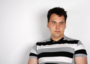 çizgili tişört Brunet adam uzakta gri arka plan üzerinde görünüyor.