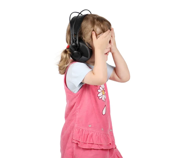 小女孩听听音乐大耳机和紧闭的双眼 b — 图库照片