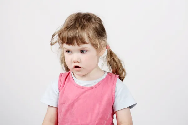 Little surprised beautiful girl looks away on white background. — Stock Photo, Image