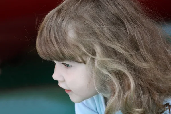 Little pretty happy girl with curly hair concentration looks awa — Stock Photo, Image