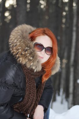 elbiseleri mutlu kız ile kış, ormandaki kürklü gülümsüyor.