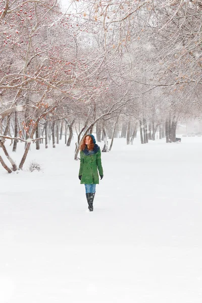 Pretty girl in green overcoat walks outdoor at winter day in par — Stock Photo, Image