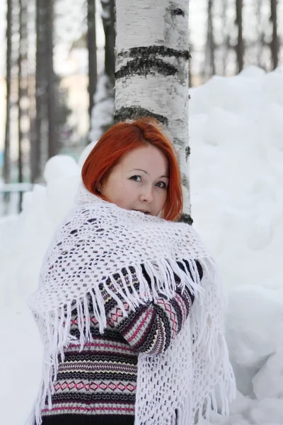 Chica bonita en chaqueta y chal blanco se encuentra cerca del árbol y enorme — Foto de Stock