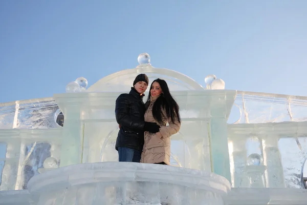 Молодая счастливая пара зимой стоит на ледяном балконе возле ледяной стены — стоковое фото
