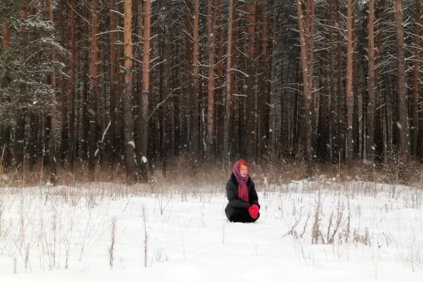 Beautiful girl sits on snow and looks away outdoor at winter day — Stock Photo, Image