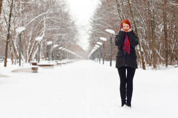 Beautiful girl in black stands outdoor at winter day in park — Stock Photo, Image